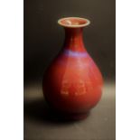 A Chinese monochrome ovoid vase, flared rim, glazed in mottled tones of red and purple blushes,