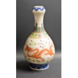 A Chinese polychrome bottle vase, decorated with a red dragon, chasing a flaming pearl,