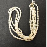 A fresh water pearl and yellow metal bead three strand necklace,