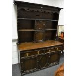 An early 20th century oak dresser, two cupboards and shelving to top,