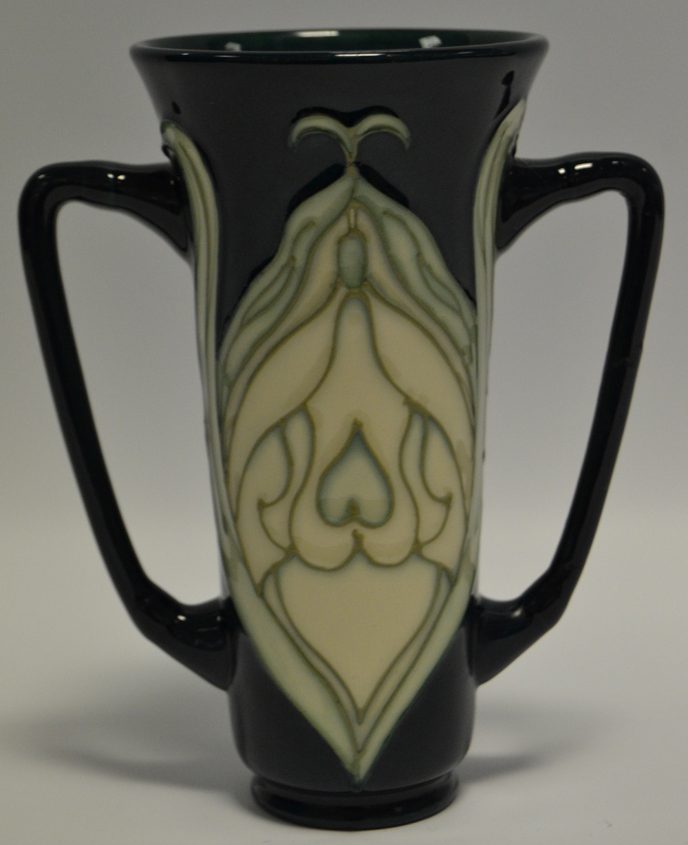 A contemporary Moorcroft two handled vases, tube lined with stylised foliage on a green ground,