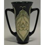 A contemporary Moorcroft two handled vases, tube lined with stylised foliage on a green ground,