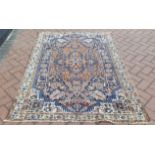 A hand woven antique Persian Malayer rug, stylized motifs on a cream and blue ground.