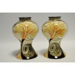 A pair of Black Ryden baluster vases, decorated with stylised yellow flowerheads and black scrolls,