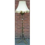 A brass standard oil lamp, converted for electricity, scroll supports with wrought iron detailing,