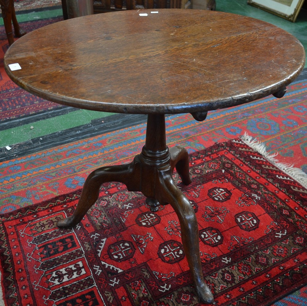 A George III oak tilt top table, bird cage support, turned column,