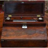 A mahogany writing slope, the hinged cover enclosing ink wells, pen stand and niches,