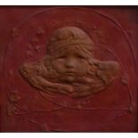 An Art Nouveau square plaque, moulded in high relief and centred by a mask of a putti,