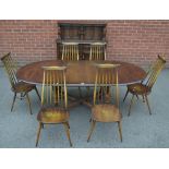 An Ercol extending dining table and chairs;