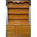 A Victorian farmhouse scumbled pine dresser, shelves over a central cupboard door,