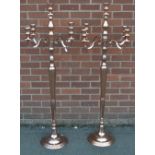 A pair of large rose coloured metal floor standing candelabra,