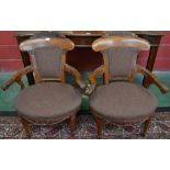 A pair of Victorian walnut library elbow chairs, of broad proportions, curved cresting rails,