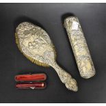 An embossed silver backed brush set; a 9ct gold coloured cheroot holder,