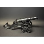 A reproduction black painted cast metal cannon,