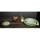 A cast metal wall mounted bell, surmounted with a Land Rover; two cast metal plaques,