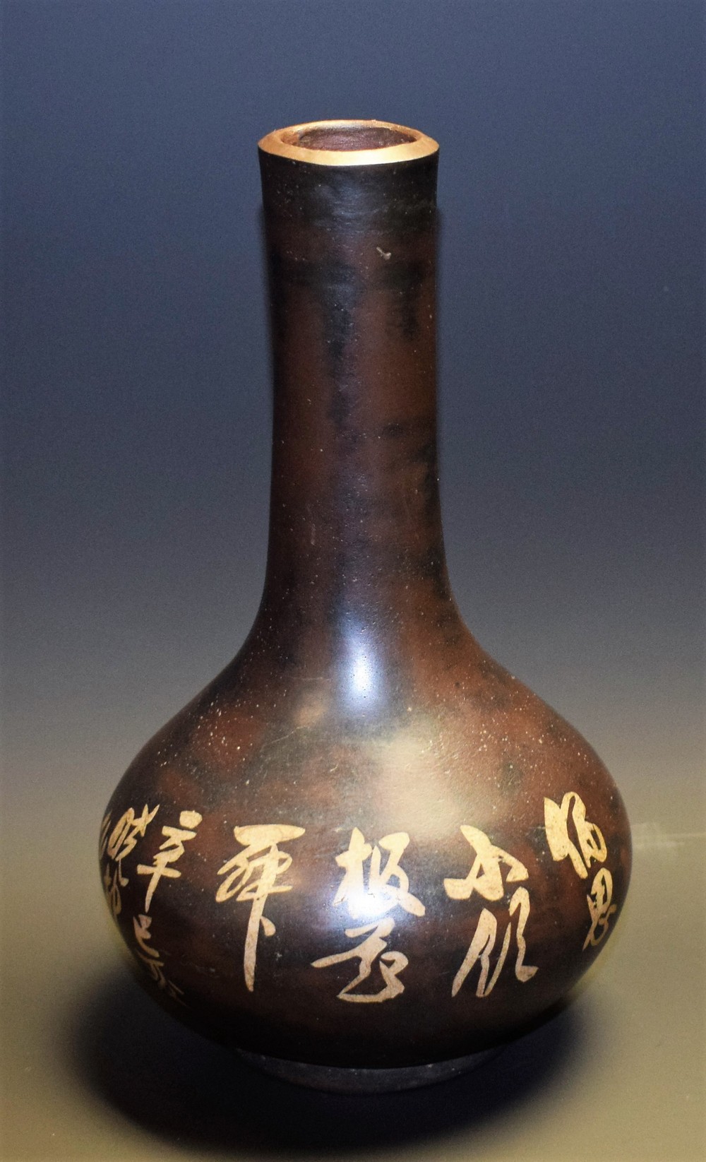 A Japanese bronzed vase, decorated with stylised flowers and foliage, with script, 21.