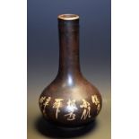 A Japanese bronzed vase, decorated with stylised flowers and foliage, with script, 21.