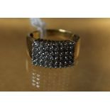 A rectangular diamond cluster ring, set with a panel of forty five round cut diamonds,