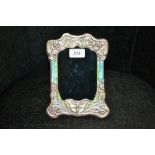 An Art Nouveau style embossed white metal frame,