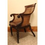 An early 19th century Scroll arm Mahogany Bergere Library Armchair with caned back and sides.