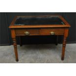 A two drawer oak writing table late 19th / early 20th century