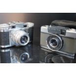 An olympus-PEN-EE camera no.744608 f3.5 28mm lens and a Paxette Braun Nurnburg camera