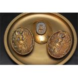 A Brass tray, three oval brass novelty nude relief plaques with with bare bottoms on reverse early
