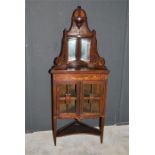 A 19th century inlaid rosewood glazed and mirrored corner display cupboard with painted decoration.