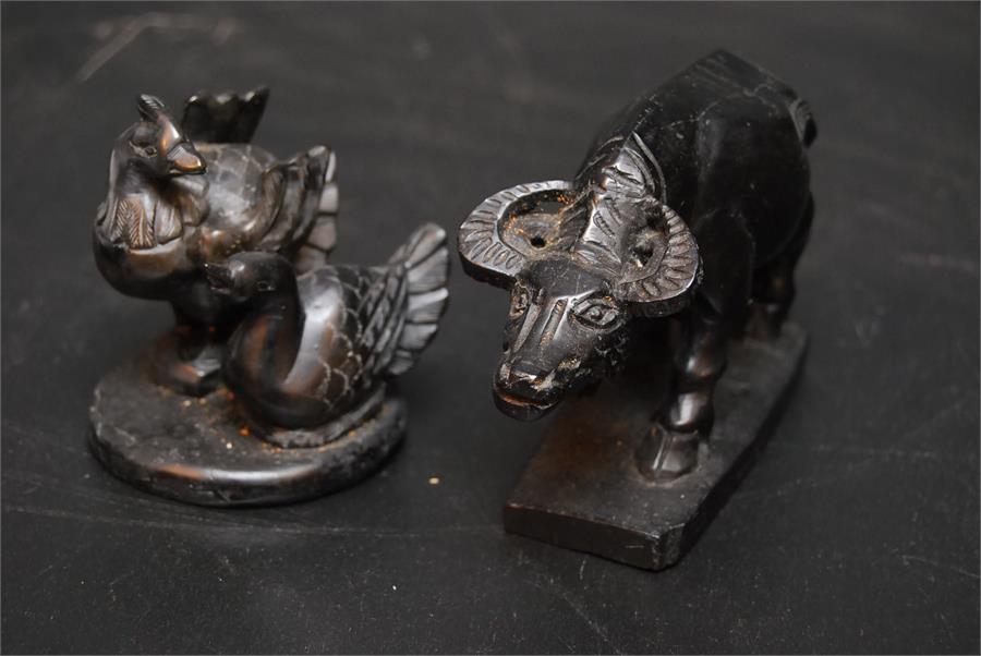 Two carved black stone animals - a buffalo, a pair of birds