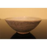 Chinese porcelain bowl, the swirling blue decoration almost concealed by the thick glaze, with an