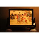 A Chinese porcelain plaque / tile set in a black lacquer frame on stepped supports. Seated and