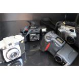 four cameras - a Nikon coolpix 990, a Kodak Brownie, an olympus trip af md, and an olympus camedia