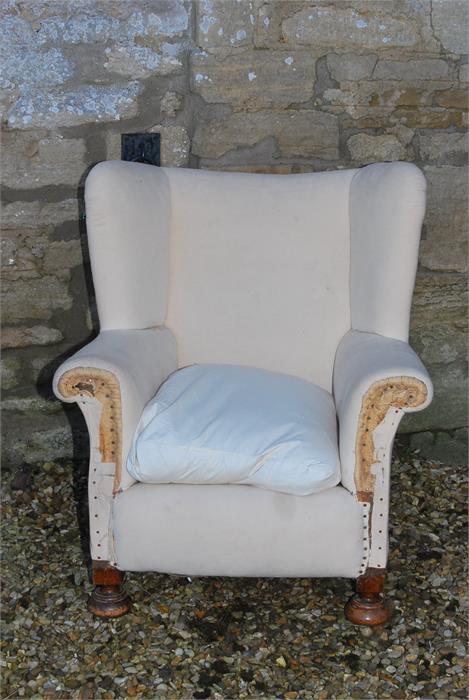 A deep seated wing armchair early 19th century - legs appear to be cut from a previous height and
