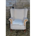A deep seated wing armchair early 19th century - legs appear to be cut from a previous height and