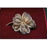 White metal / chrome / plated brooch of flower design.