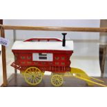 A HAND BUILT WOODEN MODEL OF A LEDGE CARAVAN WITH PLASTIC WHEELS IN A GLASS DISPLAY CABINET