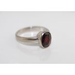 A white gold and garnet ring