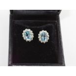 A pair of gold, blue topaz and diamond earrings