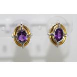 A pair of two tone gold and amethyst earrings