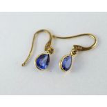 A pair of delicate gold & blue sapphire earrings