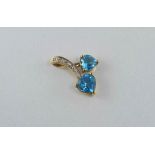 A gold, blue topaz and diamond pendant