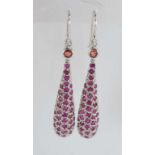A pair of silver and ruby long drop earrings
