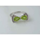 A silver and peridot bow ring