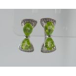 A pair of silver and peridot bow earrings