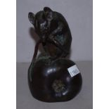 Bronze mouse chewing its tail on a apple figure