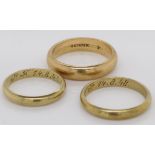 A collection of three gold wedding bands