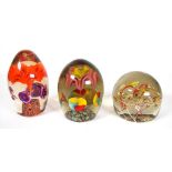 Three assorted glass paperweights