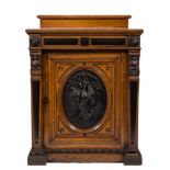 A Victorian oak, ebonised and bronzed mounted upright cellarette cupboard: with a ledge back,