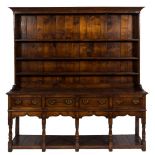 An 18th Century oak dresser with a later shelved superstructure:, having a moulded cornice,