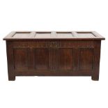 An early 18th Century oak rectangular coffer:, of moulded panel construction, having a hinged top,